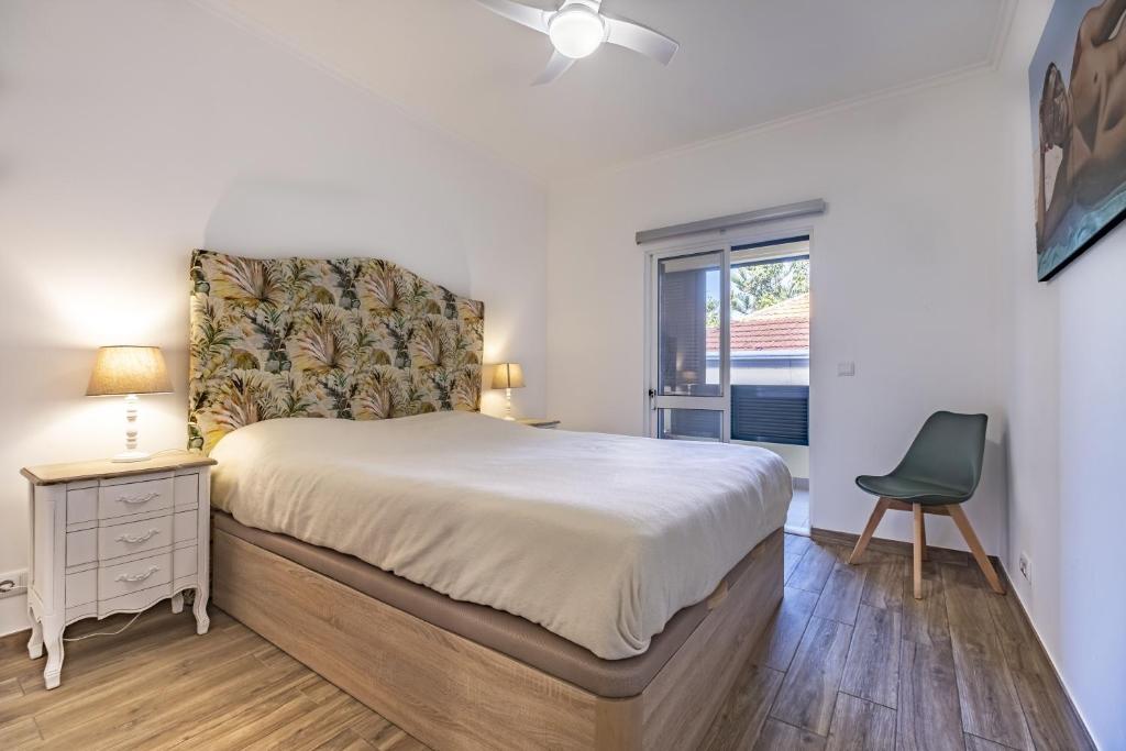 a bedroom with a bed and a chair and a window at Apartment - The Historical Center of Funchal in Alojamento Local in Funchal