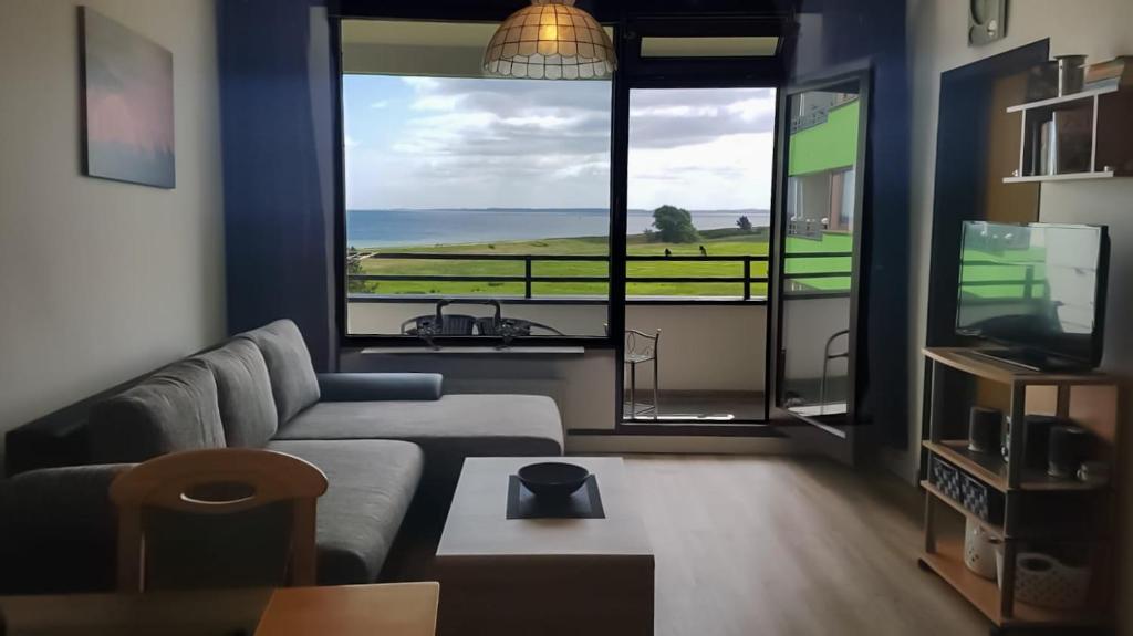 a living room with a couch and a large window at Ferienwohnung mit Meerblick in Damp
