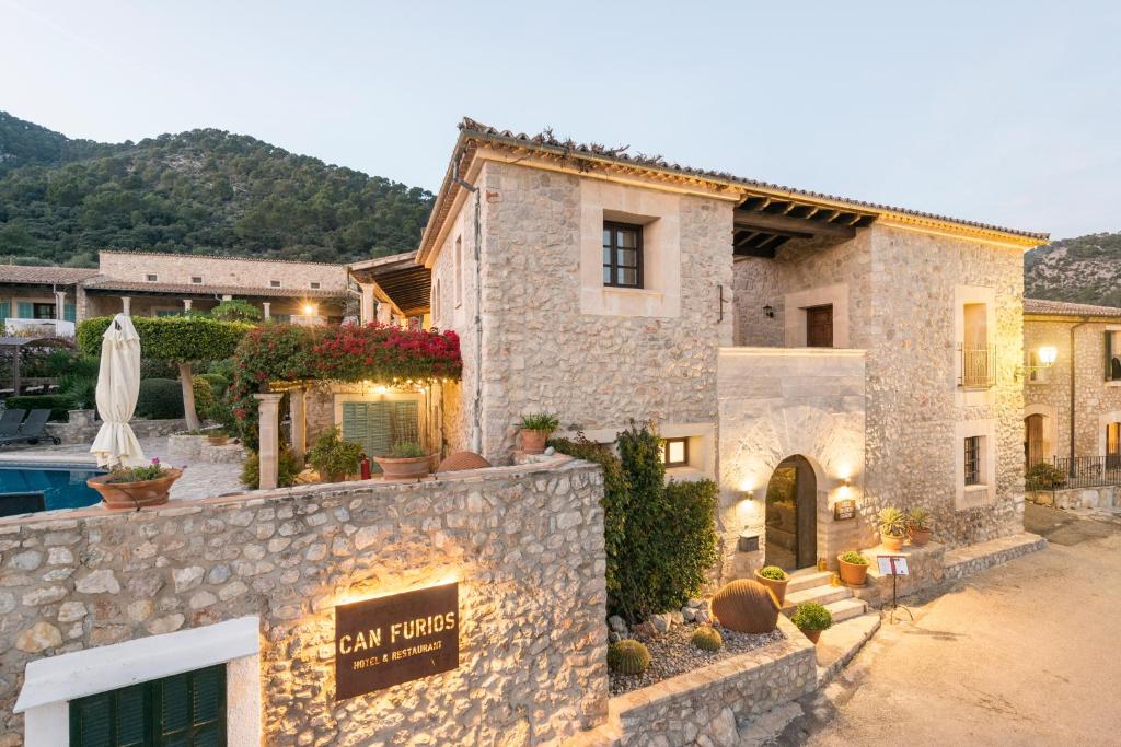 een stenen huis met een zwembad en een resort bij New Can Furios Hotel by Can Calco Hotels in Selva