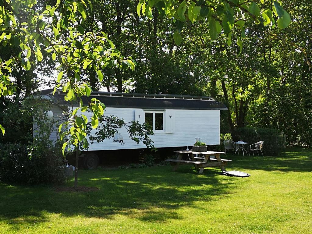 een witte trailer in een tuin met een picknicktafel bij Bed & Breakfast Markelo in Markelo