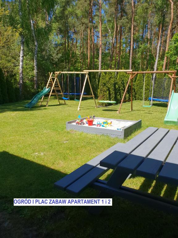 park z placem zabaw z ławką i huśtawką w obiekcie Apartamenty Amalia w mieście Szary Dwor