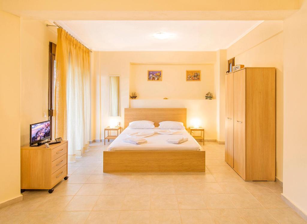 a bedroom with a bed and a flat screen tv at Marina's Elegance in Kriopigi