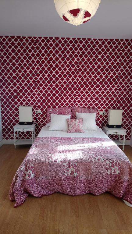 Schlafzimmer mit einem Bett mit rosa Tagesdecke in der Unterkunft Rua Nova Apartment 28 PS4 y Netflix a 200m Catedral in Santiago de Compostela