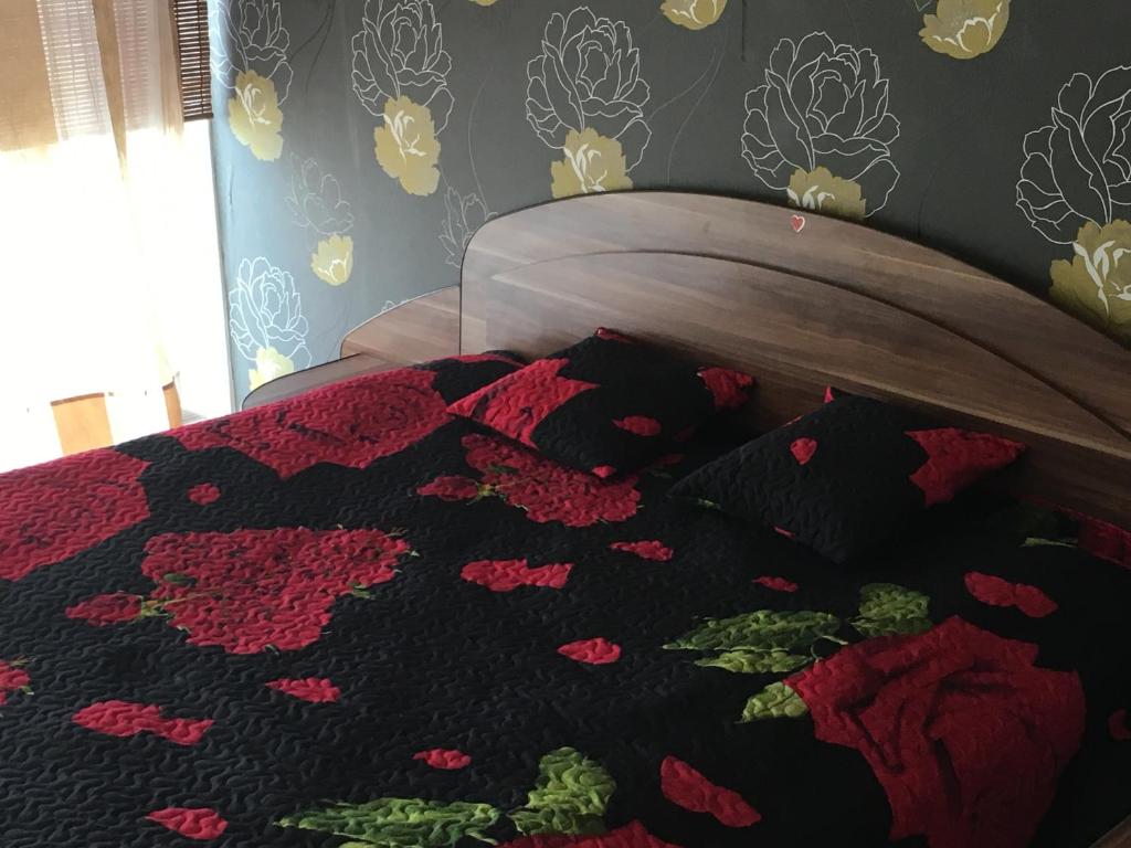 a bed with a black and red blanket on it at Burės apartamentai in Klaipėda