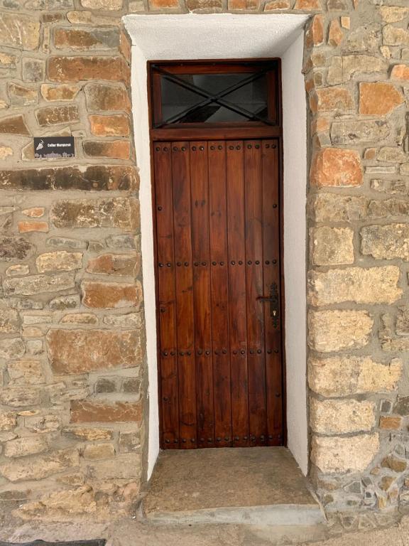 uma porta de madeira castanha numa parede de pedra em Casa Marqueso em Figuerola de Orcau