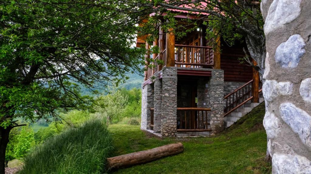 une cabane en rondins avec une véranda et une terrasse dans l'établissement FERN FARM ECO RESORT, à Mojkovac