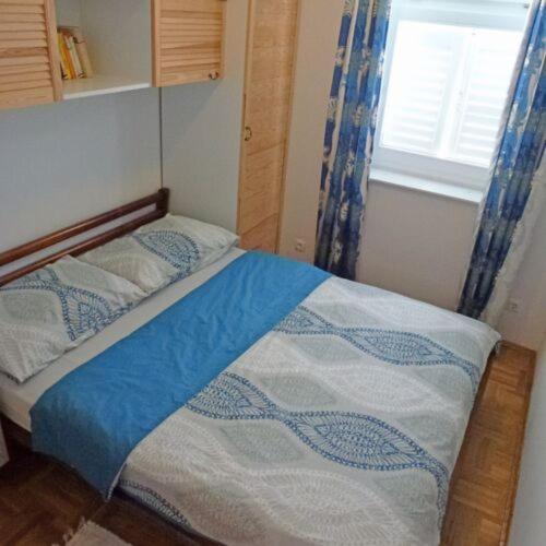 un piccolo letto in una camera con finestra di Apartman Vesna 4 persons a Njivice