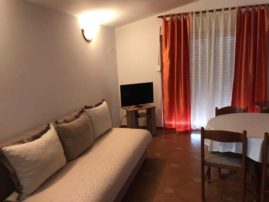 un soggiorno con divano e tavolo con TV di Guesthouse MB Knezevic a Budua