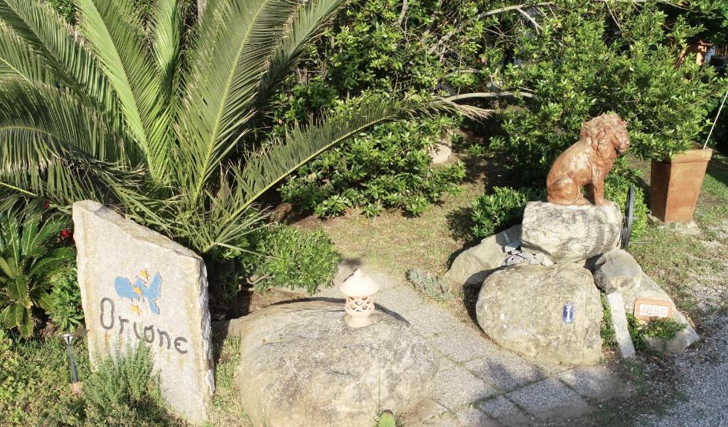 a statue of a bear on a rock with a candle at Agriturismo Orione in Marina di Campo