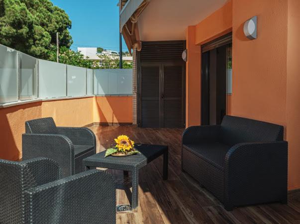 a balcony with two chairs and a table with flowers on it at Parrot’s House in Lloret de Mar