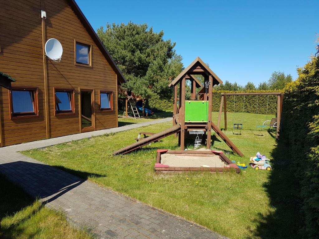 a playground in a yard next to a house at Domek letniskowy Młyn in Karwieńskie Błoto Pierwsze