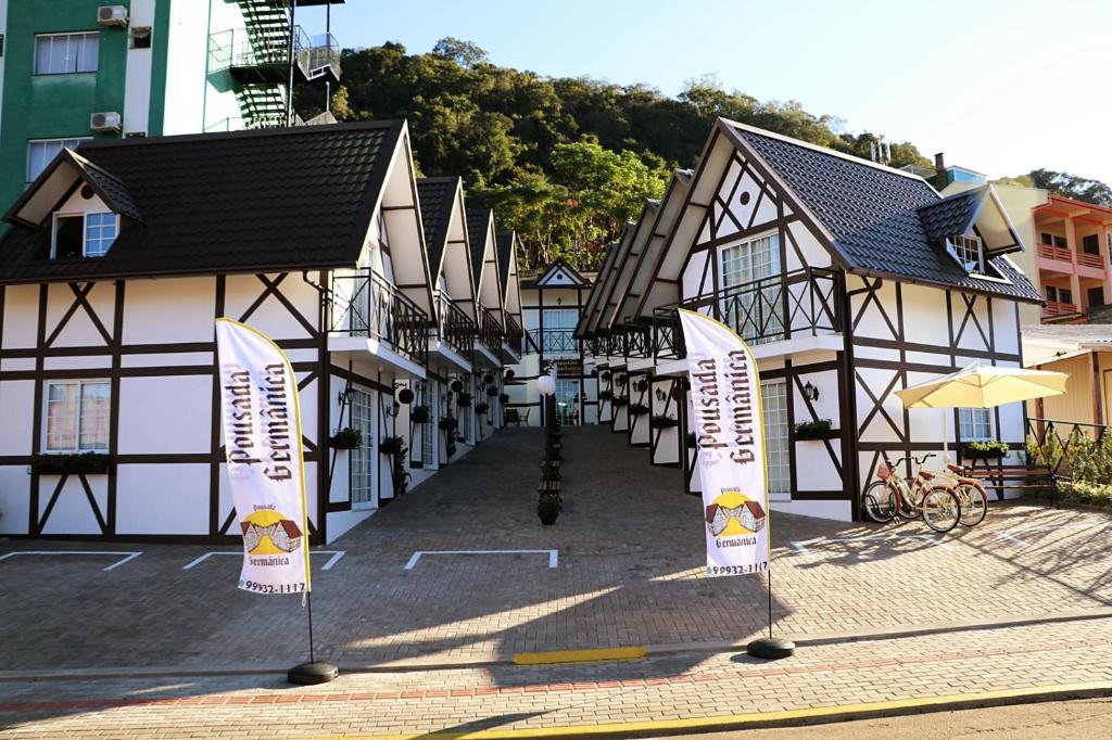 uma fila de edifícios com placas à frente deles em POUSADA GERMÂNICA em Marcelino Ramos