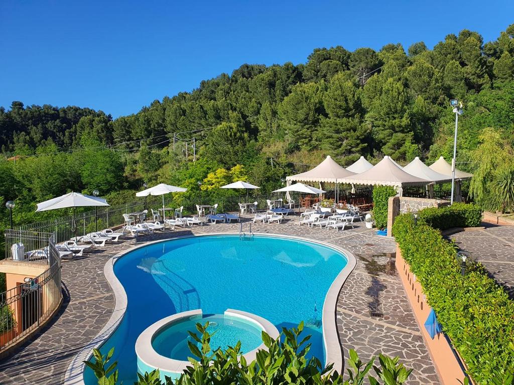 - une piscine dans un complexe avec des chaises et des parasols dans l'établissement Paradiso Country House, à Pescara