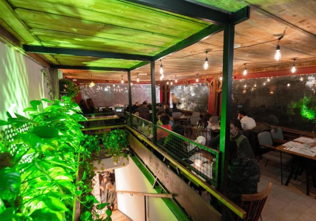 un restaurant avec des plafonds verts et des plantes sur un balcon dans l'établissement Beach studio, à Limassol