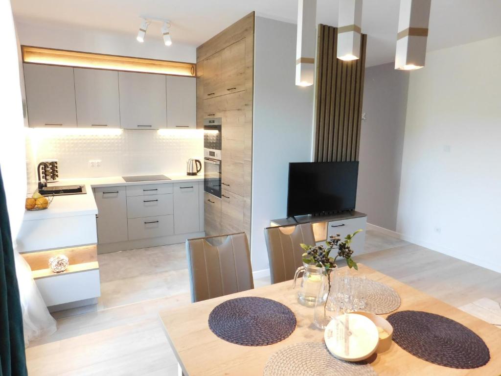 a kitchen and dining room with a table and chairs at Apartament Zielone Wzgórze in Jelenia Góra