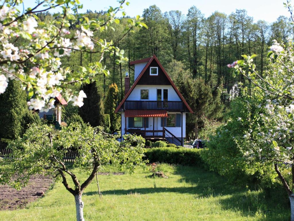 a house in the middle of a field with trees at Dom wakacyjny w Kiersztanowie Ładnie Tu in Mrągowo