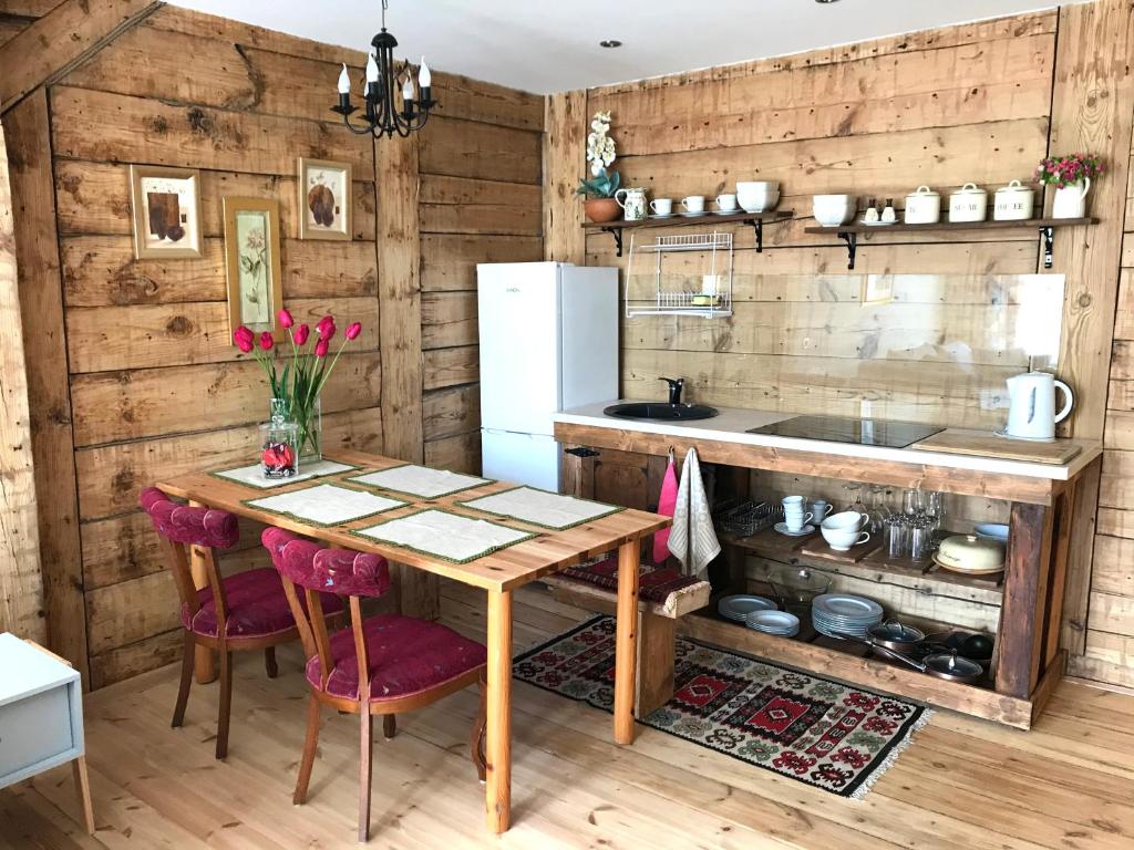 eine Küche mit einem Tisch und einem Kühlschrank in der Unterkunft Apartamenti Starp Krastiem in Liepāja