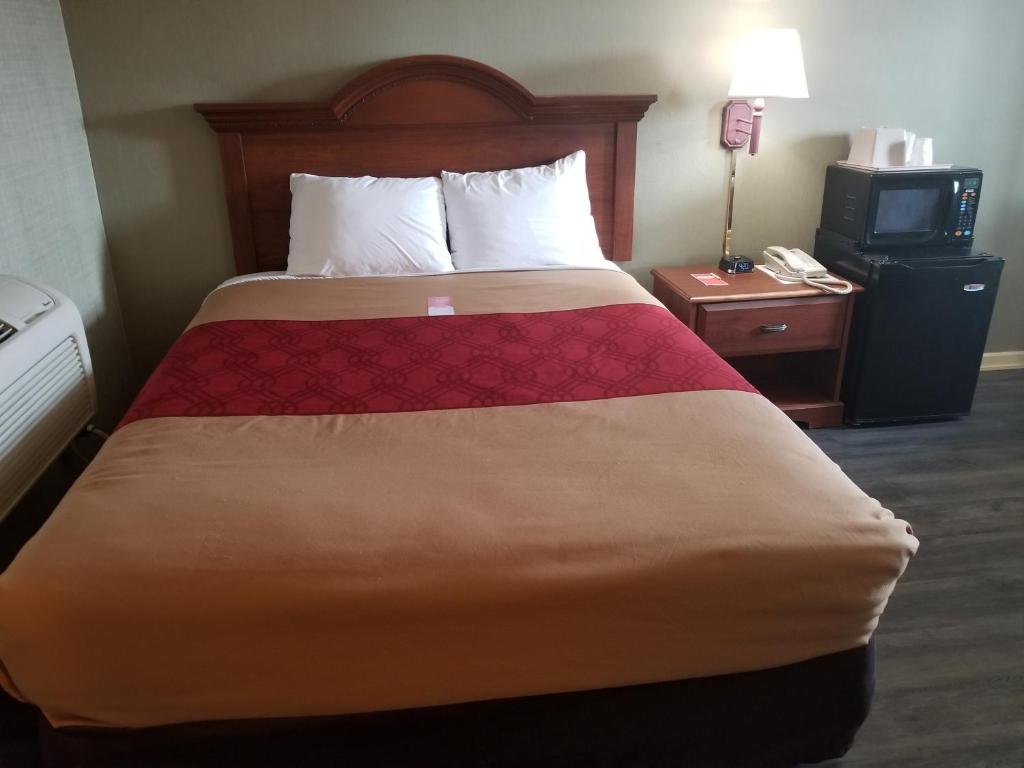 um quarto de hotel com uma cama e uma televisão em FALLS INN em Newton Falls