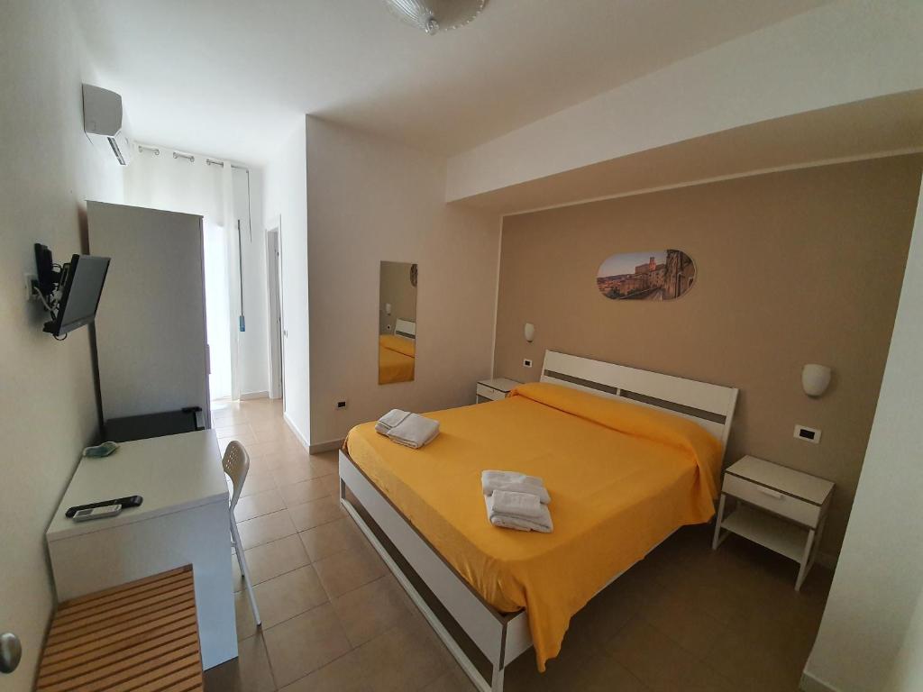 een slaapkamer met een oranje bed en een televisie bij Casale Marcalia - bed & breakfast in Corigliano Calabro