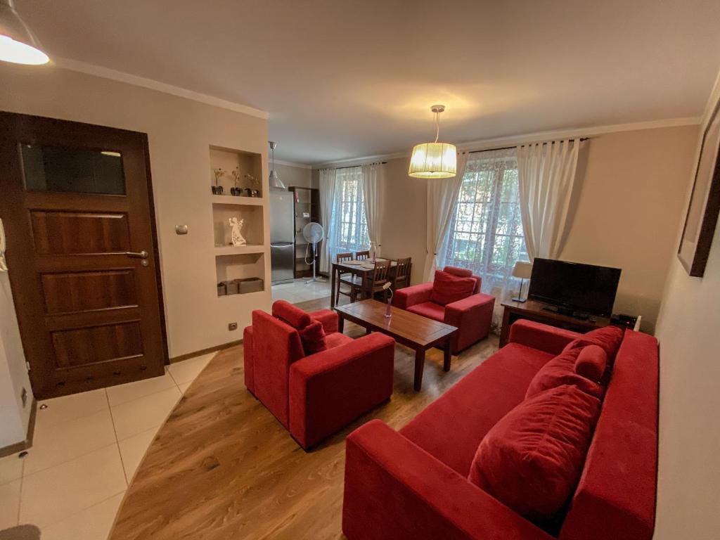 een woonkamer met een rode bank en rode stoelen bij Apartament Przy Długosza in Sandomierz