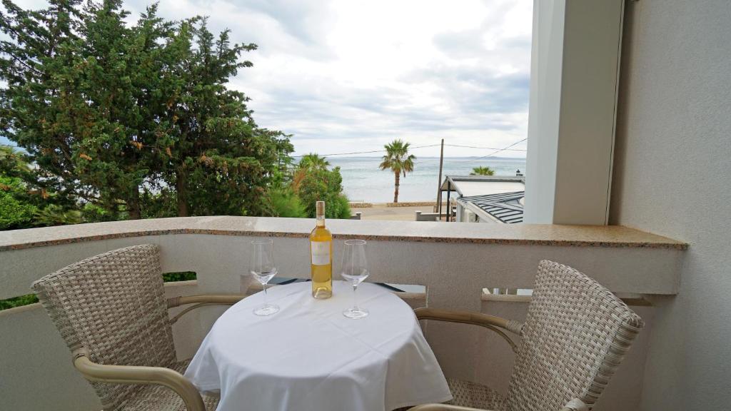 Una botella de vino sentada en una mesa en un balcón en Apartments Paradiso, en Vir