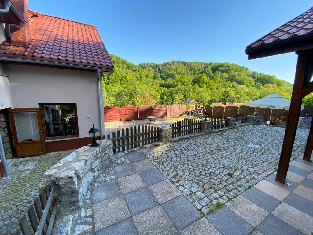 una casa con una valla y una pasarela de piedra en Willa Justynka en Bystrzyca Górna