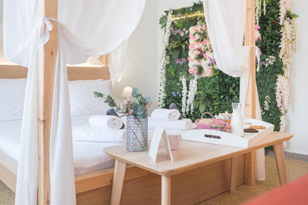 sypialnia z łóżkiem i stołem z ręcznikami w obiekcie Na'maste Apartments w Atenach