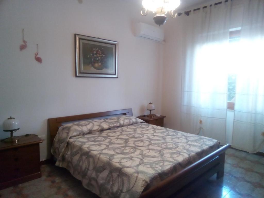 sypialnia z łóżkiem i zdjęciem na ścianie w obiekcie B & B Il Mirto 2 w mieście SantʼAntìoco
