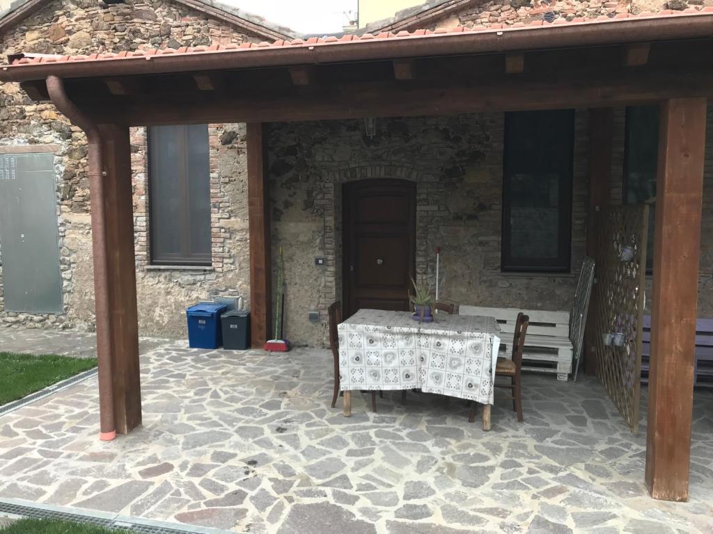 une terrasse en pierre avec une table et un banc dans l'établissement Alle case il pozzetto, à Suvereto