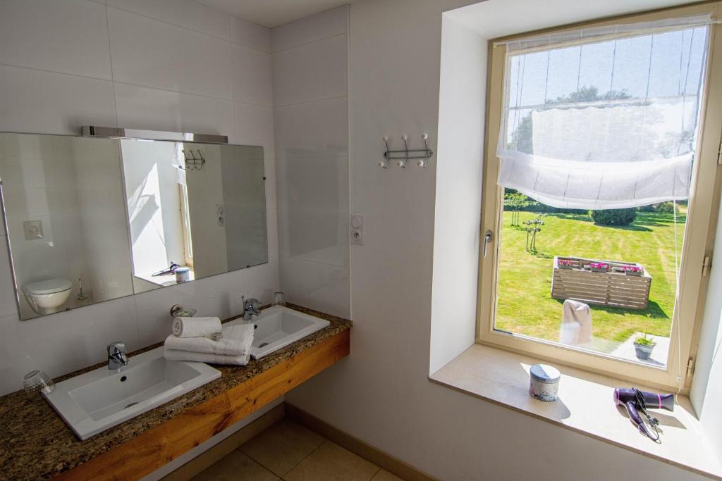 a bathroom with a sink and a window at Domaine de kerbillec in Theix
