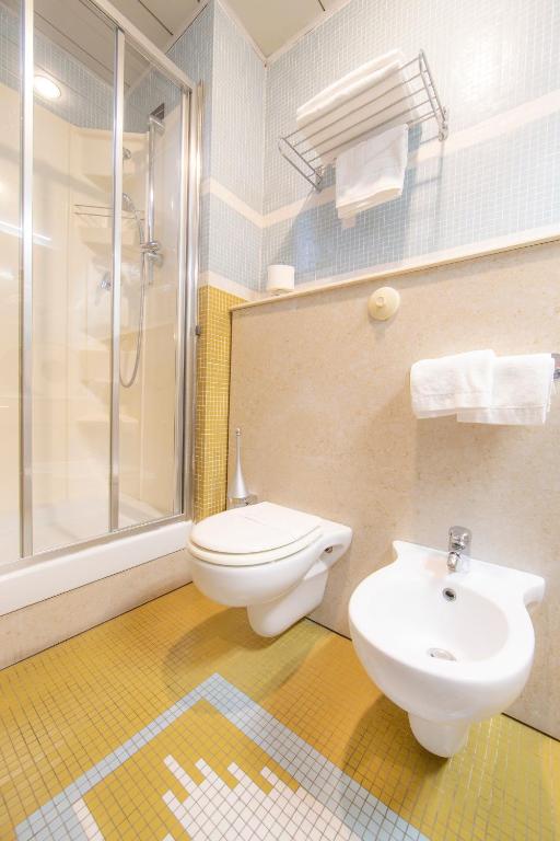 a bathroom with a toilet and a sink and a shower at Hotel Della Baia in Portovenere