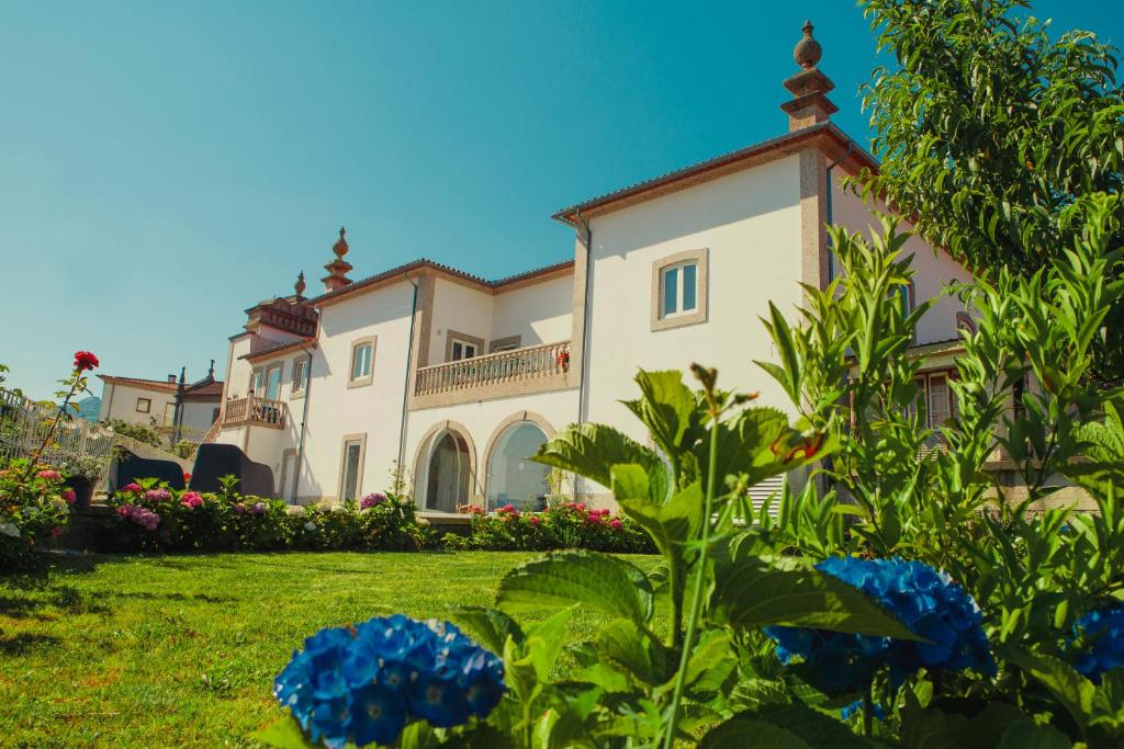 une grande maison avec un jardin en face de celle-ci dans l'établissement Casa Victória, à Ponte da Barca