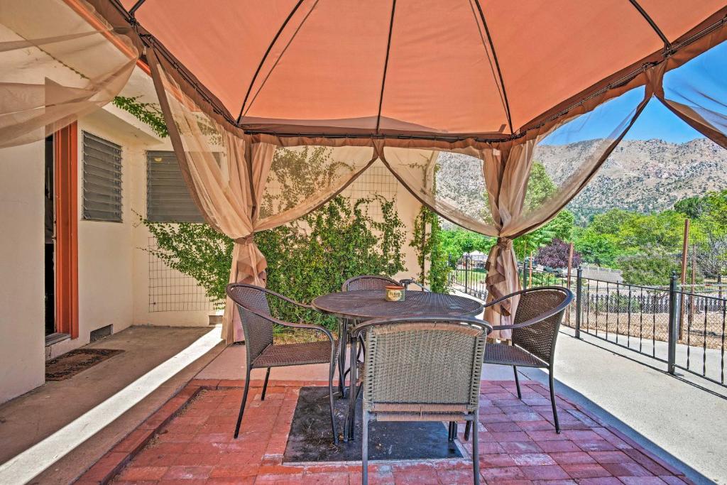 a table and chairs on a porch with an umbrella at Scenic Kernville Home - Walk to Downtown and River! in Kernville