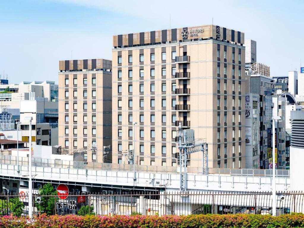 a large building in the middle of a city at Hiyori Hotel Osaka Namba Station in Osaka