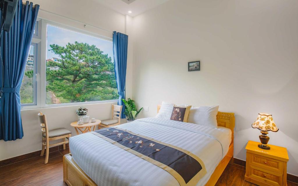 Un dormitorio con una cama grande y una ventana en Mây Trắng Villa, en Da Lat