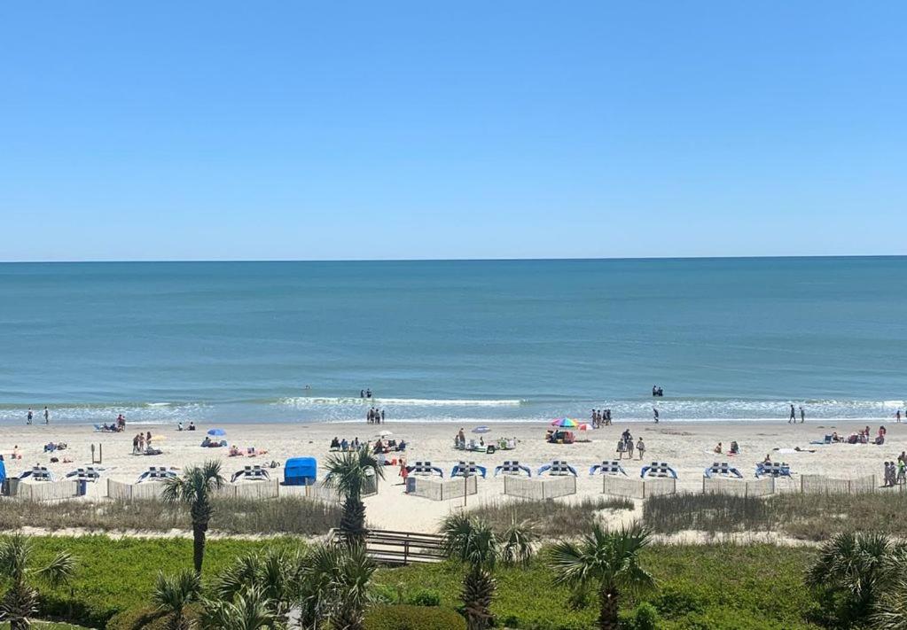 un grupo de personas en una playa cerca del océano en Ocean Dream Vacation en Myrtle Beach