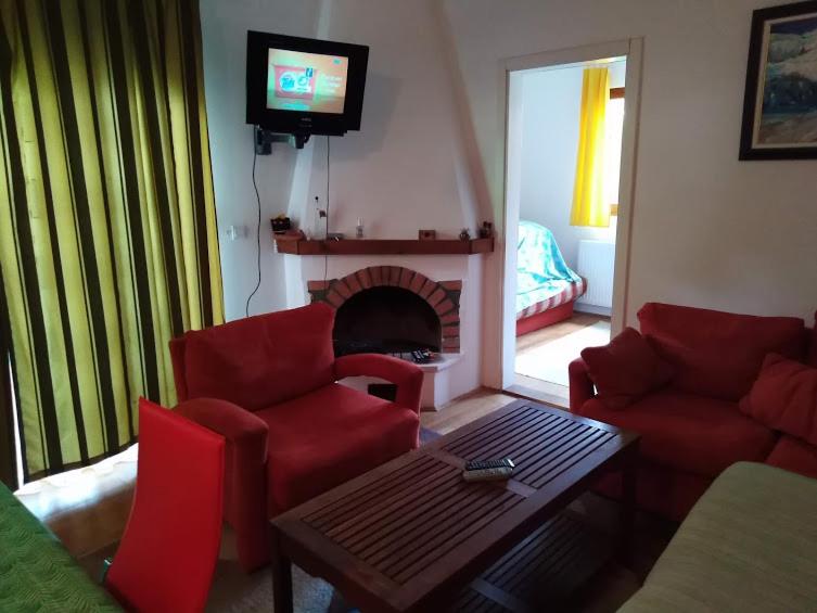 a living room with red furniture and a fireplace at Milica in Zlatibor