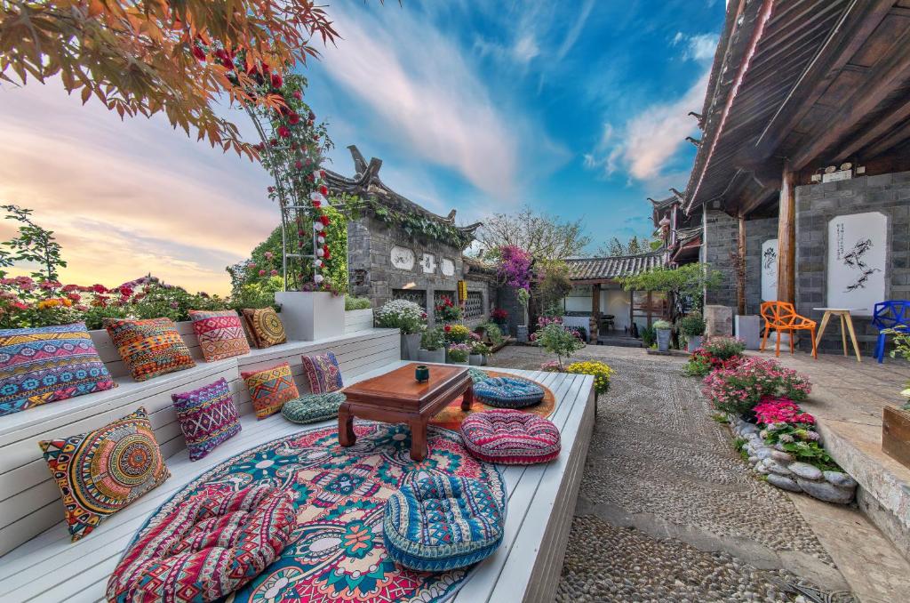 a patio with colorful pillows and a table on a patio at Lijiang Mountain View Boutique Inn in Lijiang