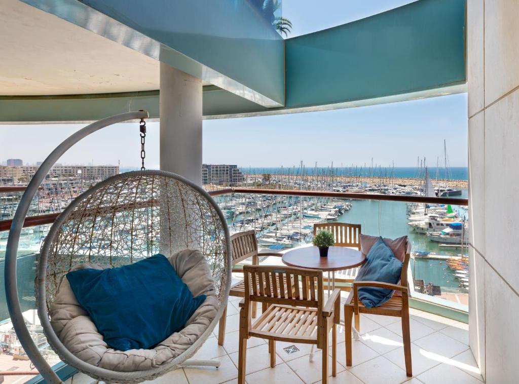 balcone con sedie e tavolo con vista sul porto di Beach front lux apartment (pool/gym/parking) a Jlil