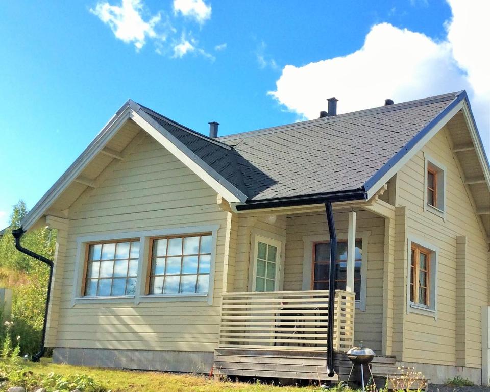 a small house with a gray roof at Himos Villi Cottages in Jämsä