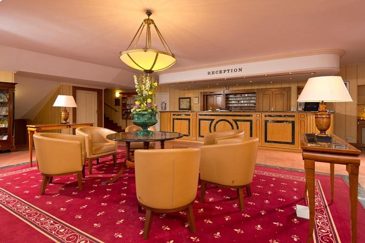 a living room with a table and chairs and a kitchen at Hotel am Schlosspark in Gotha