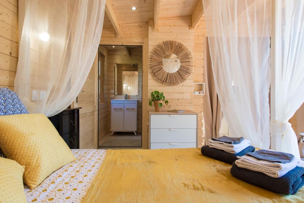 ein Schlafzimmer mit einem Bett und ein Badezimmer mit einem Spiegel in der Unterkunft Le Petit Flo in Flocourt