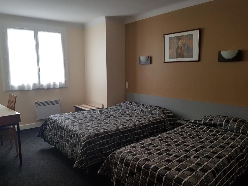 Postel nebo postele na pokoji v ubytování Hôtel Saint Sébastien