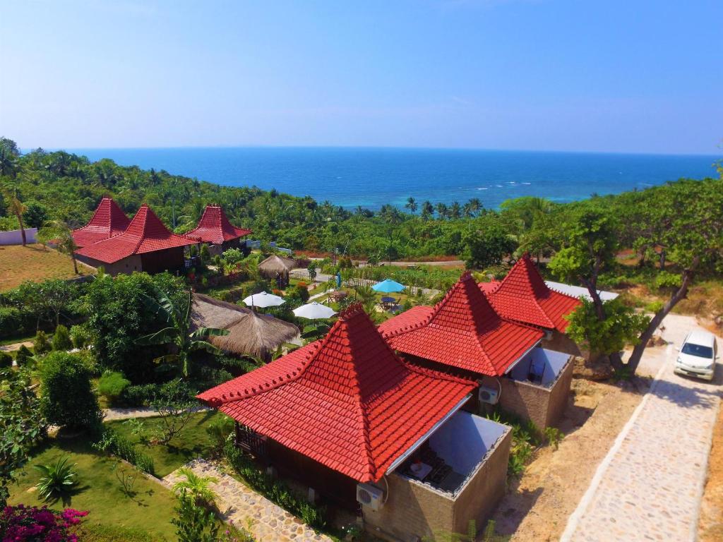 einem Luftblick auf ein Resort mit roten Dächern und dem Meer in der Unterkunft Mirabelle Joglo Village in Karimunjawa