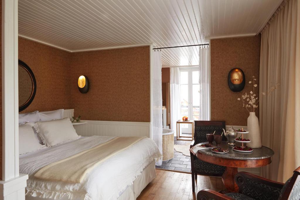 a bedroom with a bed and a table in a room at Grand Hotel Soleil d'Or in Megève
