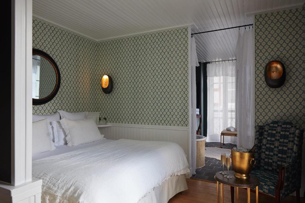 a bedroom with a white bed and a chair at Grand Hotel Soleil d'Or in Megève
