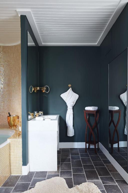 a bathroom with blue walls and a sink and stool at Grand Hotel Soleil d'Or in Megève