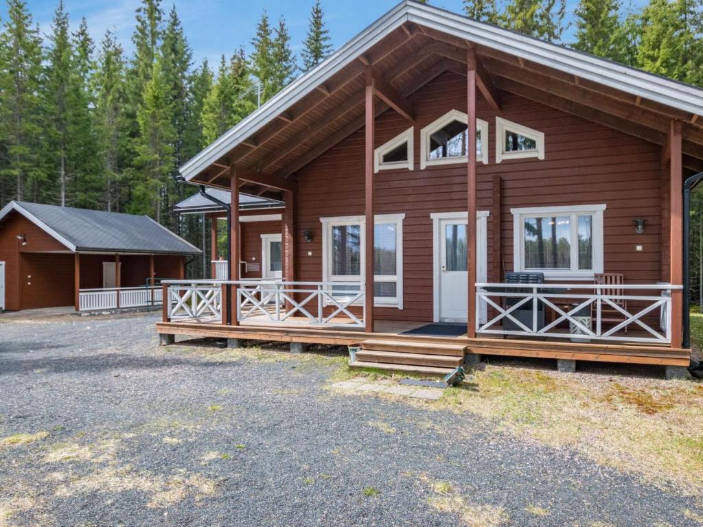 eine Blockhütte mit einer Veranda und einem Haus in der Unterkunft Holiday Home Metsäpirtti by Interhome in Saukkokoski