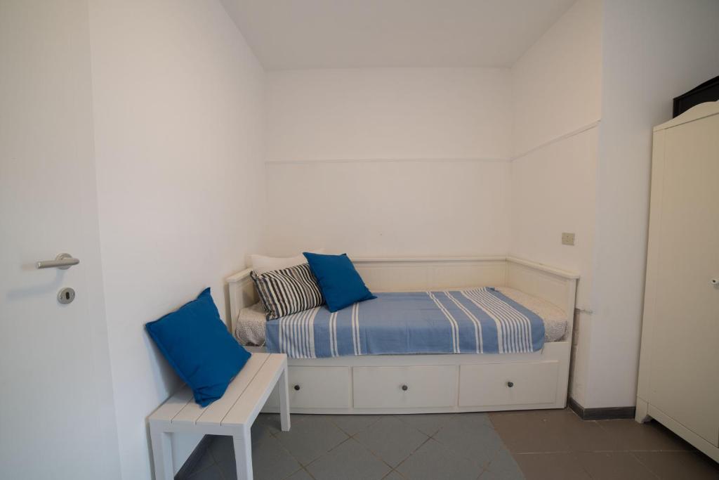 a bedroom with a bed with blue pillows and a chair at Villa Lara in Polignano a Mare
