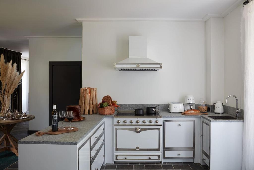 a white kitchen with a stove and a sink at Grand Hotel Soleil d'Or in Megève